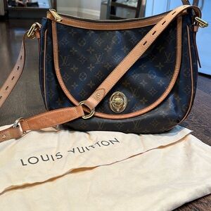 Louis Vuitton leather logo messenger bag with brass detailing.